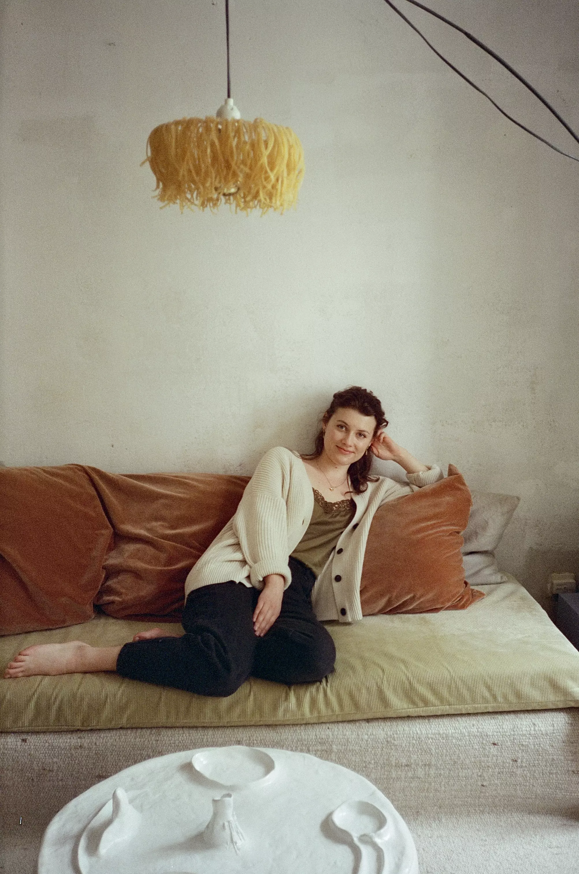 Portrait photo of a female sat in on a sofa in an apartment