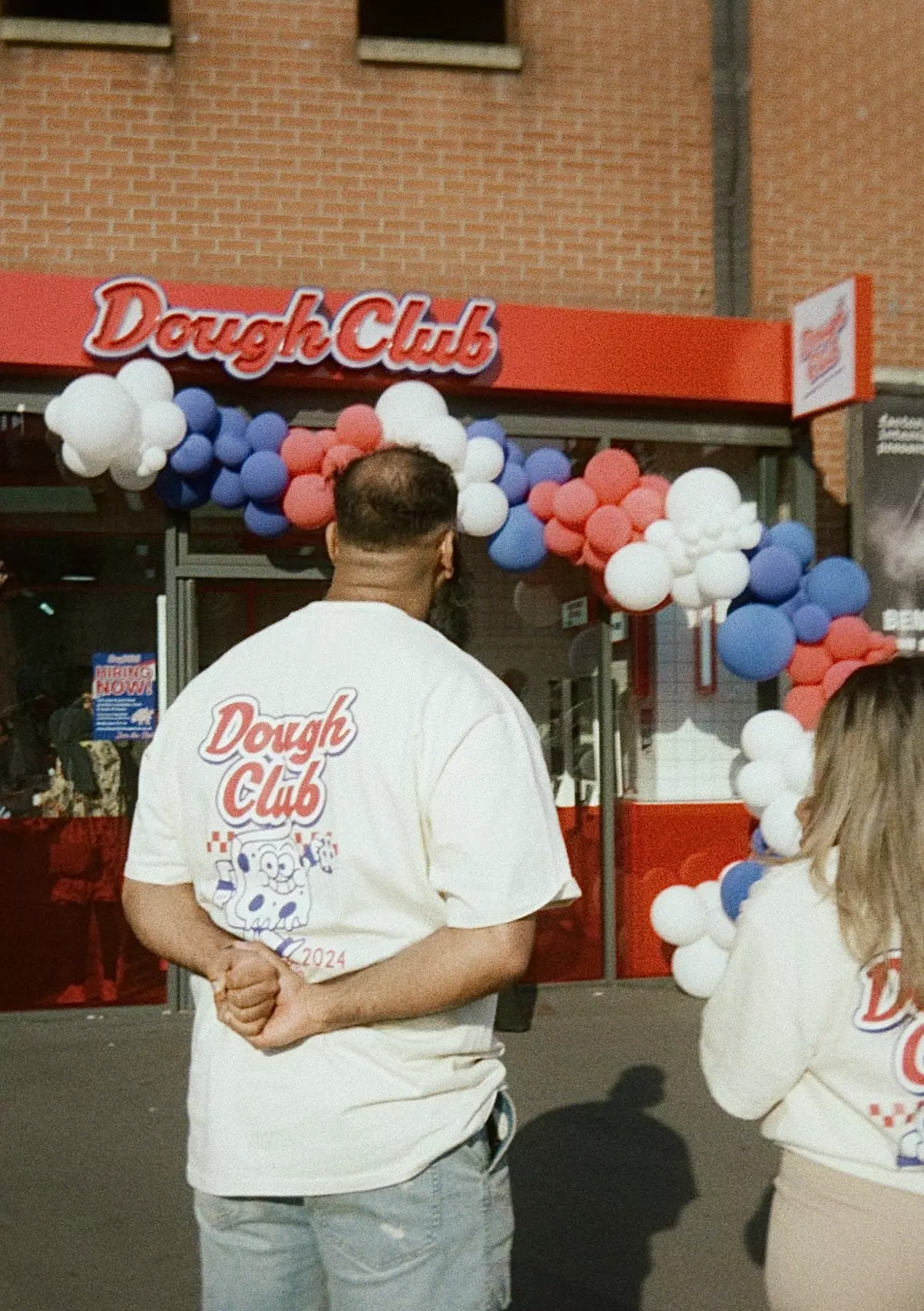Dough Club Pizza packaging set against a white tiled wall