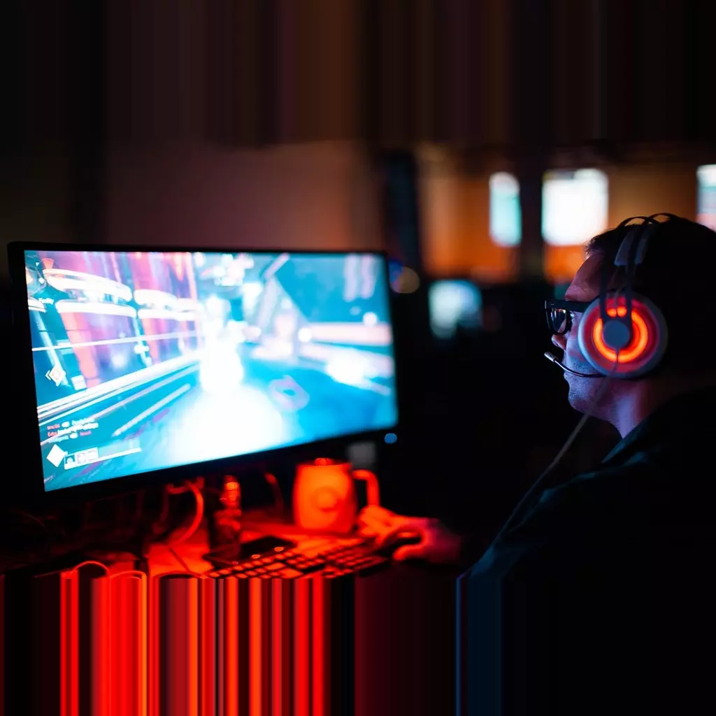 Image of guy sat at PC playing games