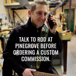 Rod on phone with guitar in workshop Jan 2025 with message.jpg
