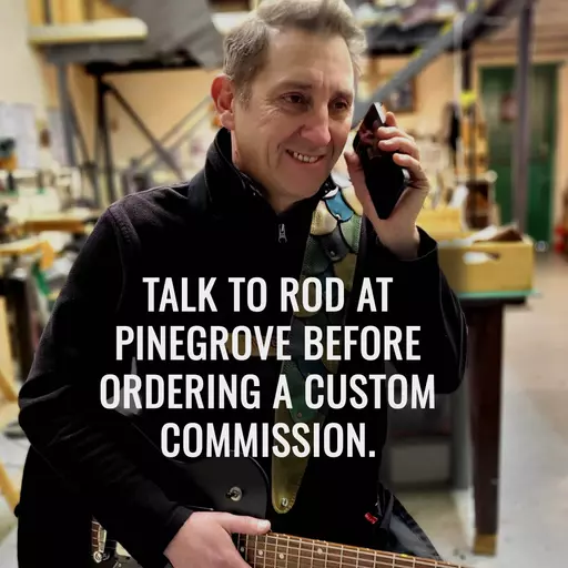 Rod on phone with guitar in workshop Jan 2025 with message.jpg