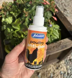 Bottle of poultry anti peck held in hand