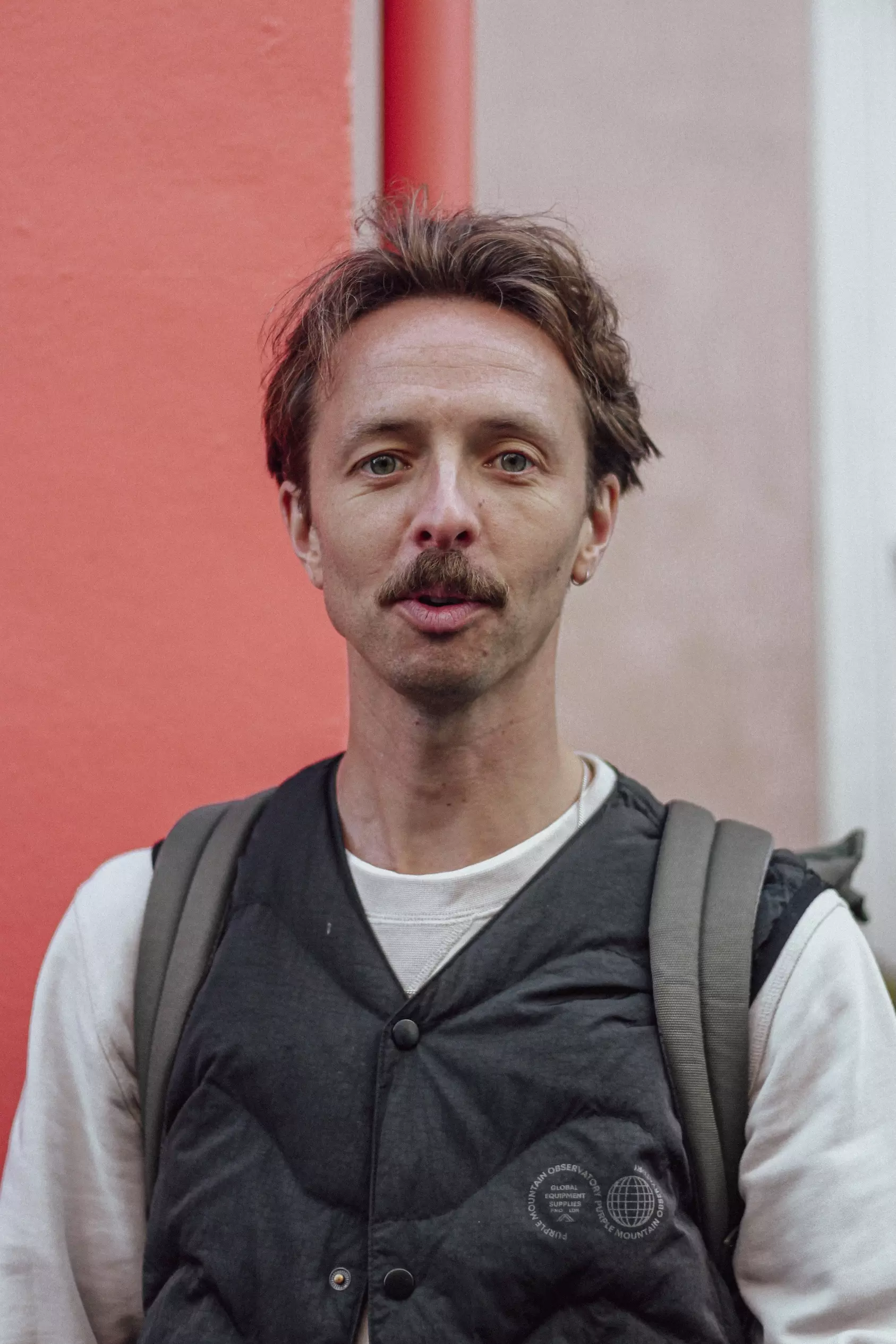 Mid-shot of male in front of a red wall