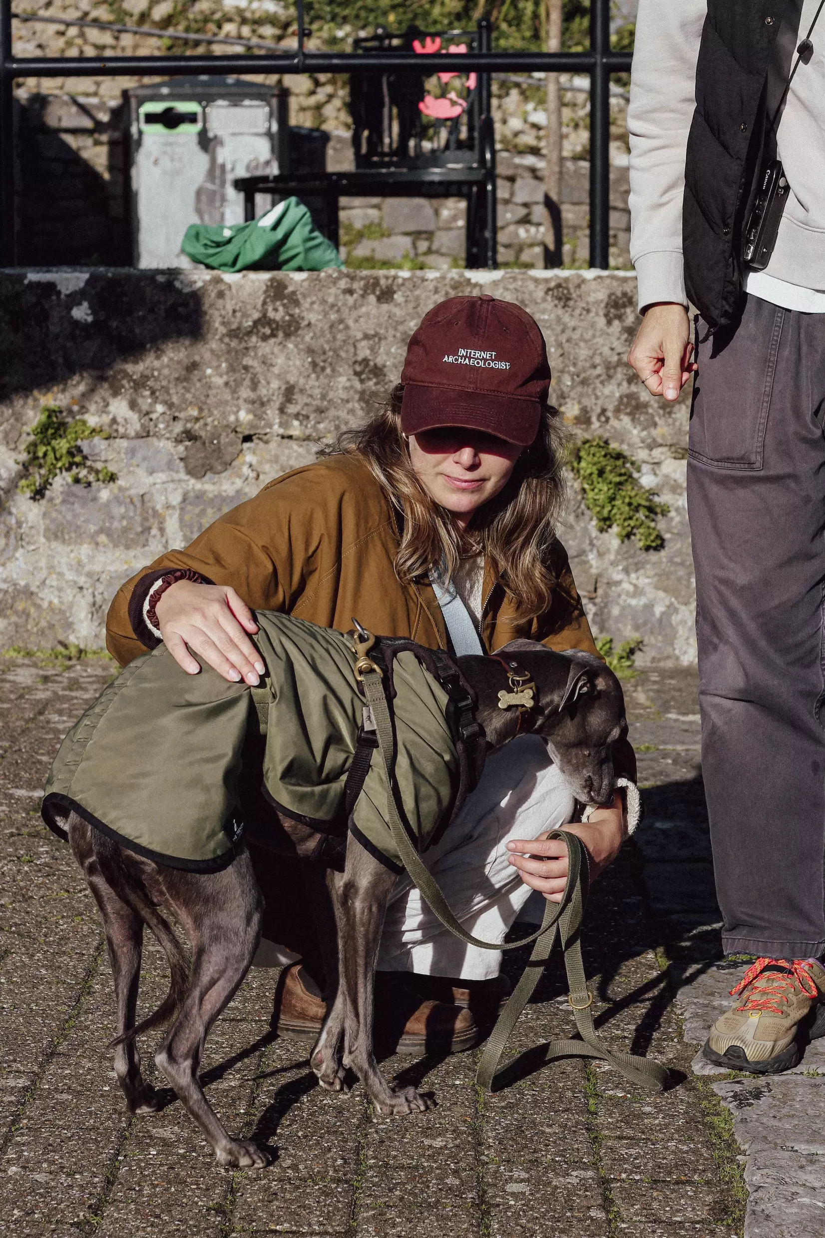 Female crouched down with a blue whippet