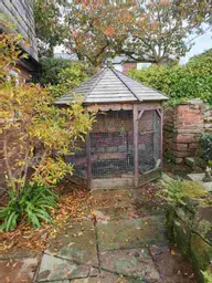 Octagonal aviary located on patio in autumn.jpg