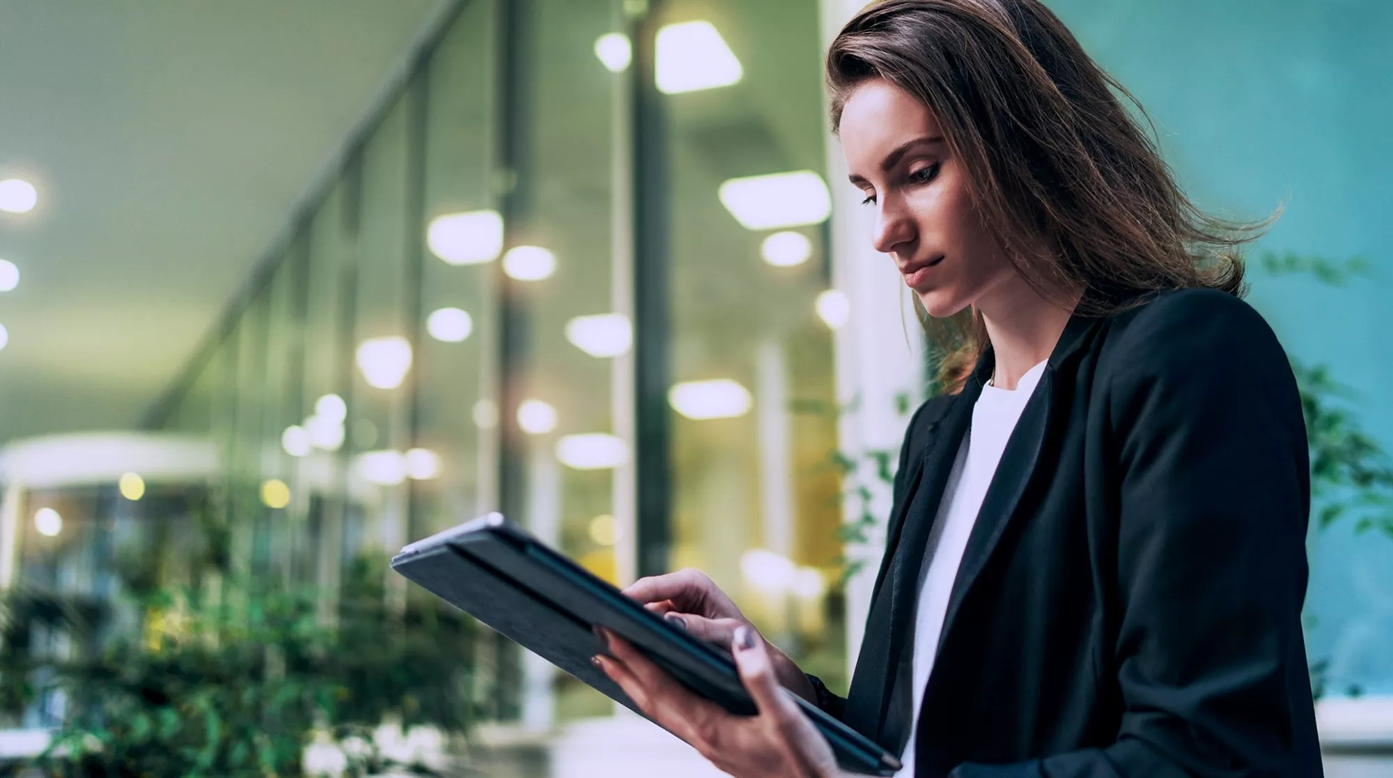 women in office holding a tablet