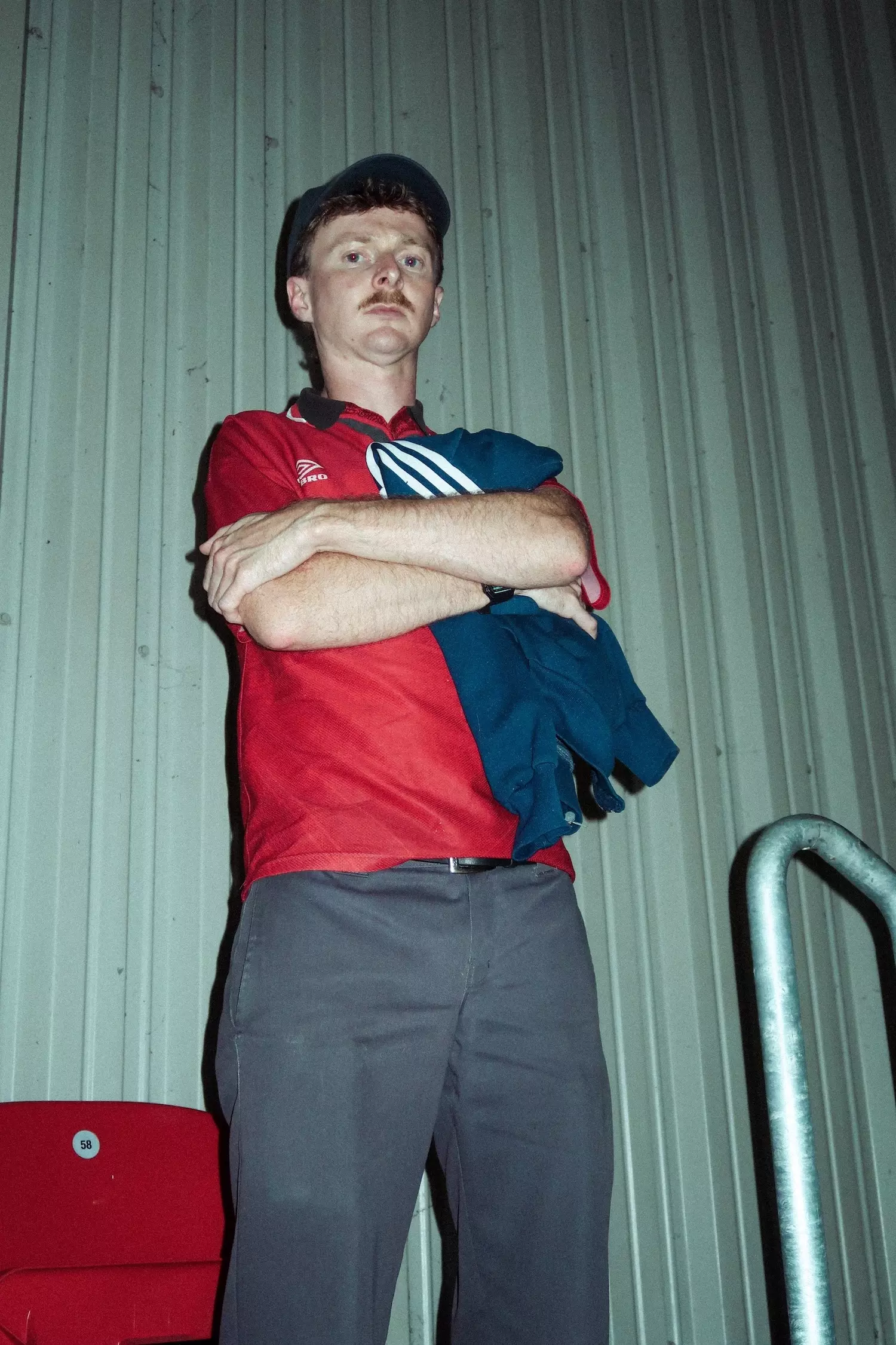 Mid shot of a male looking serious to camera with a red Manchester United shirt on