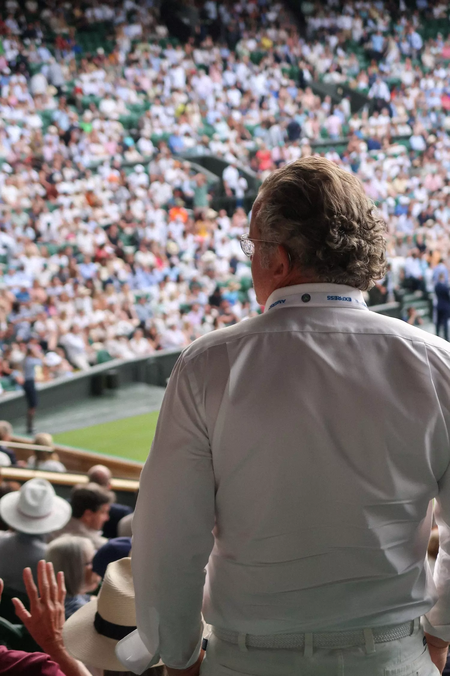 Centre Court, Day One at Wimbledon with a man in focus and and the crowd in the distance