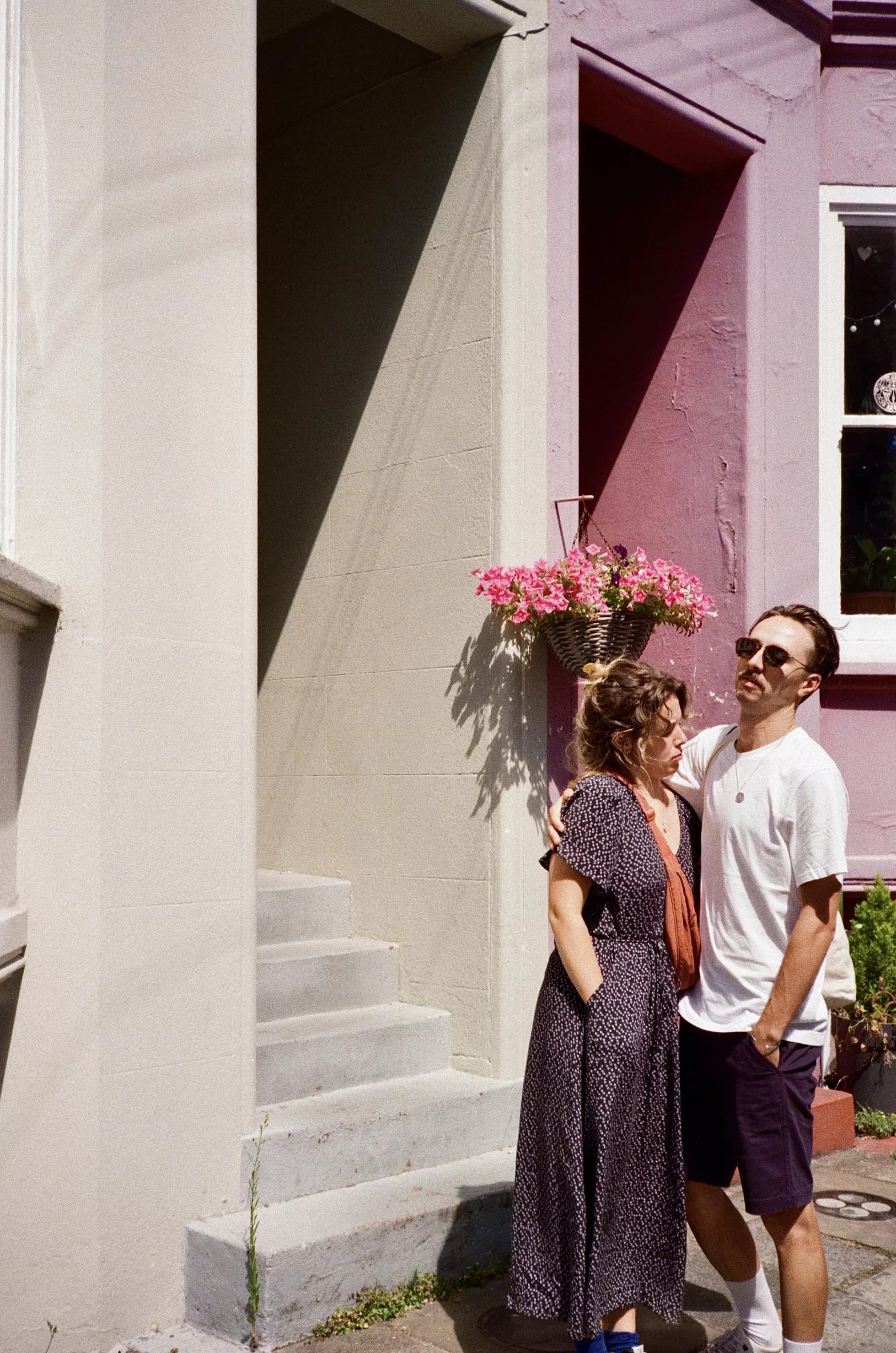 A couple standing in front of coloured terraced street in Brighton