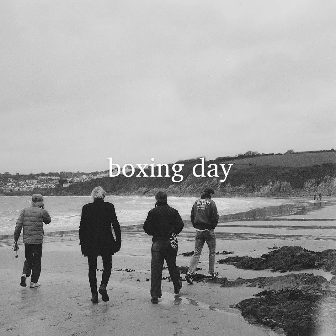 Black and white photo of a family walking on a beach