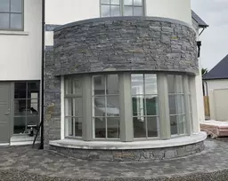 Natural Liscannor stone cladding on a curved stone wall