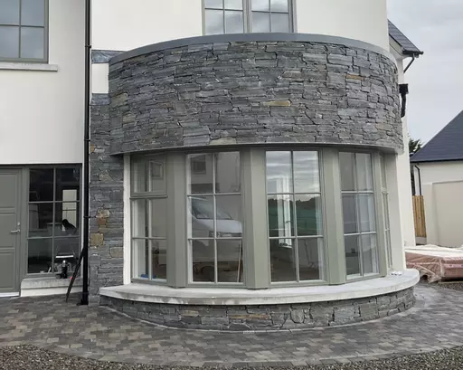 Natural Liscannor stone cladding on a curved stone wall