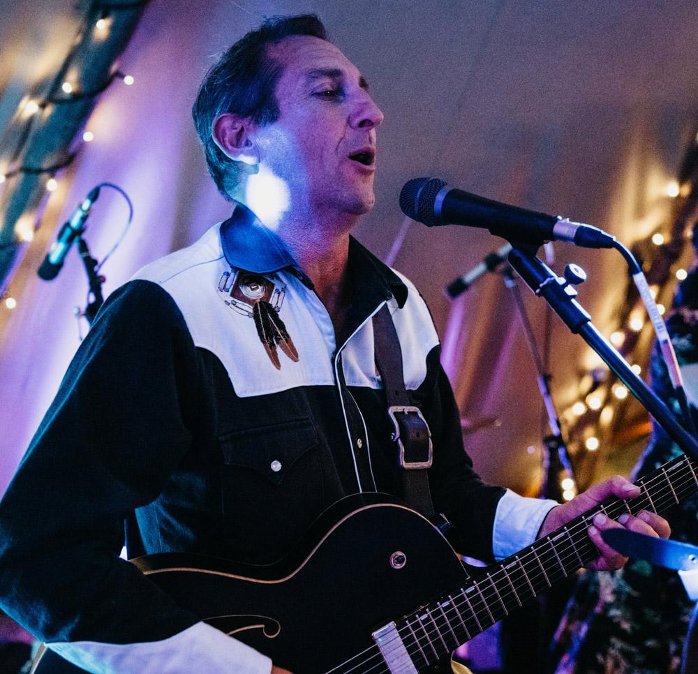 Rod Boyes of Pinegrove Leather on stage playing guitar (2).jpg