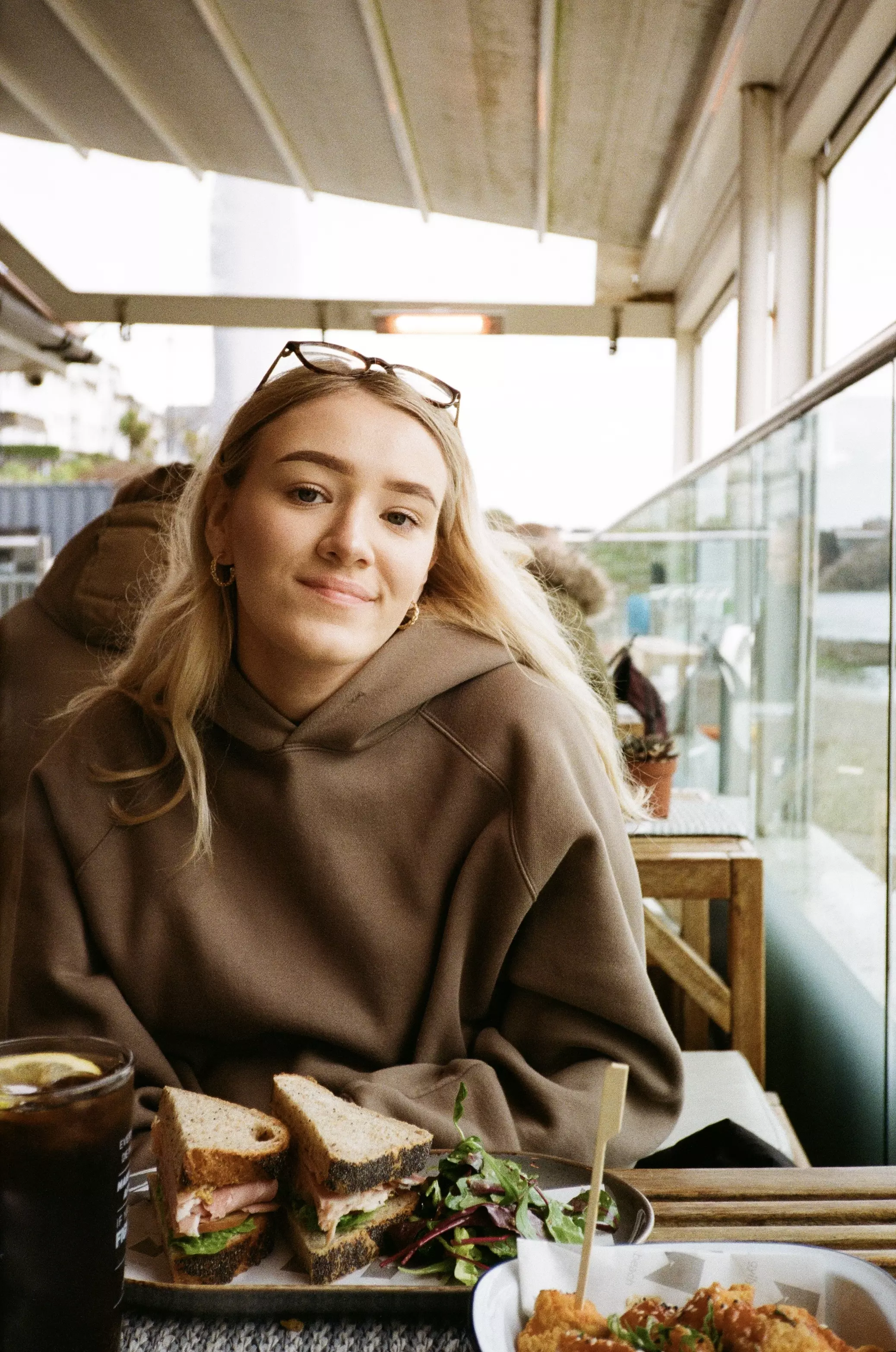 Young female sat across the table at a beach cafe with lunch