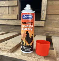 A can of Johnsons Poultry Housing Spray next to a chicken coop