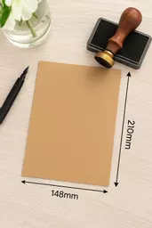 A5 kraft card sheet on a wooden desk with a pen and ink stamp beside it, ideal for creative stationery or DIY projects.
