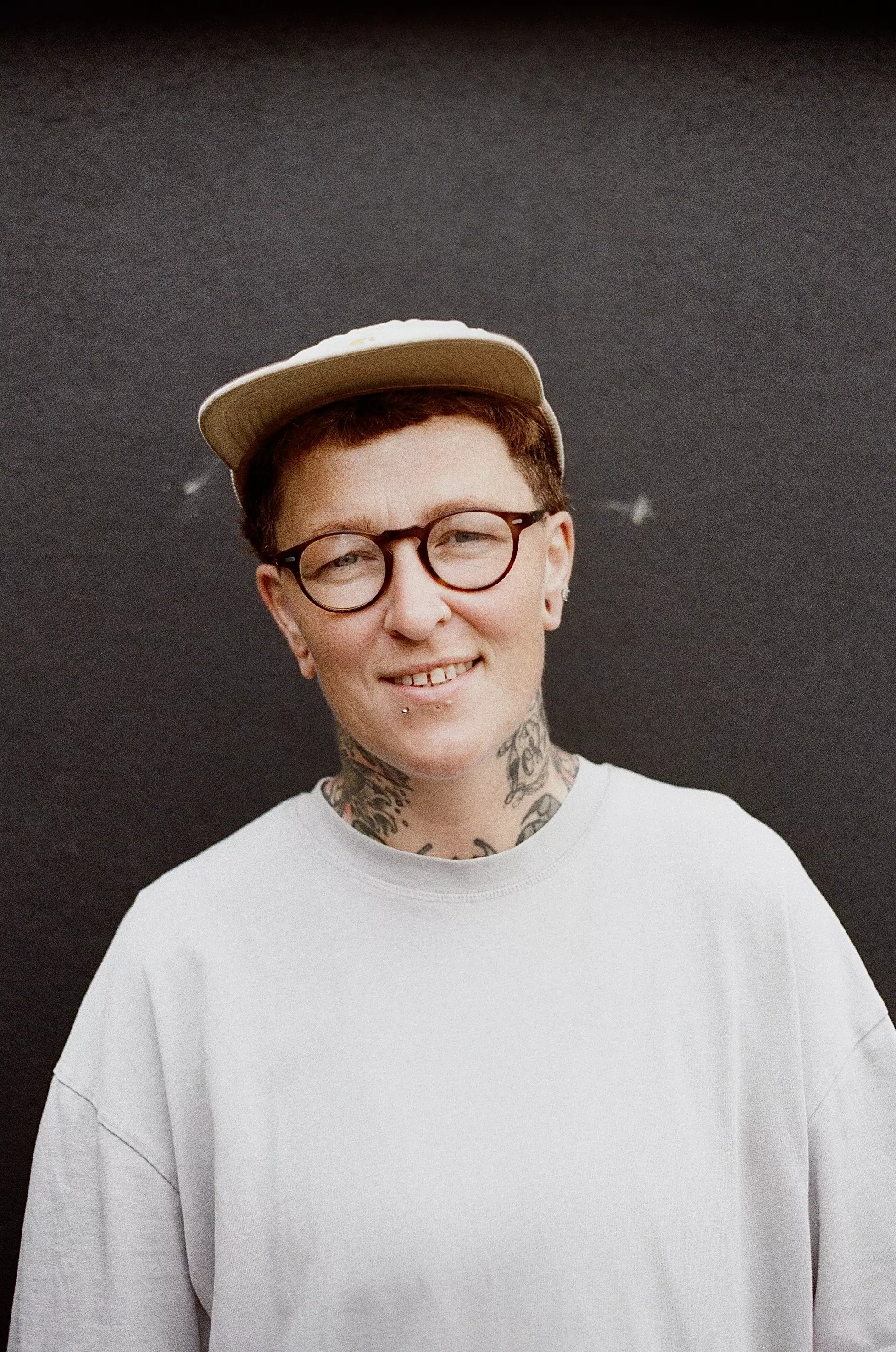 Mid shot of a female smiling to camera in front of a dark grey wall