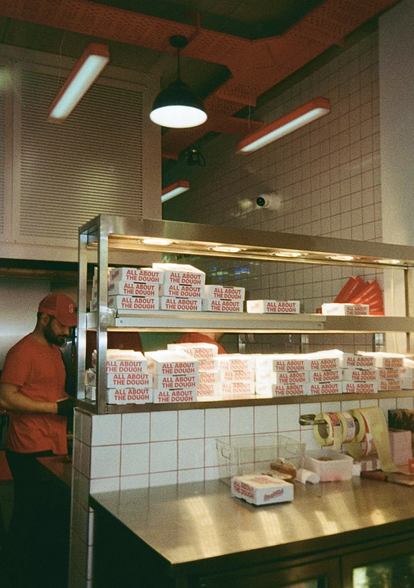 Dough Club Pizza packaging set against a white tiled wall