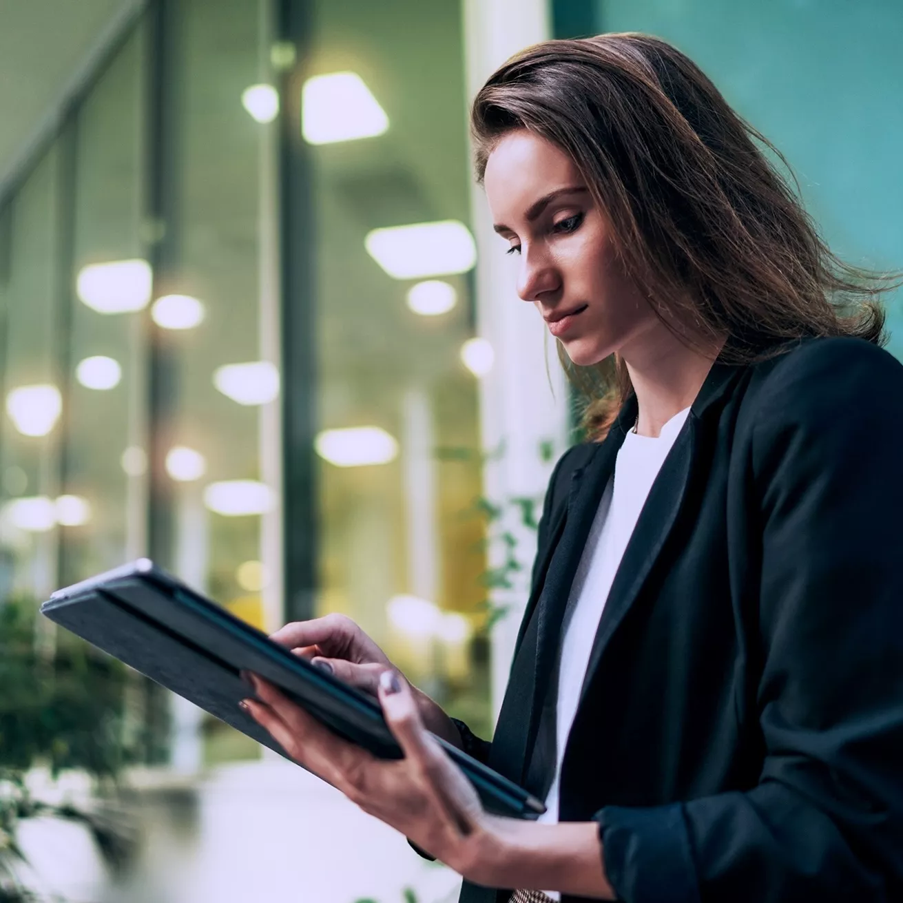 women in office holding a tablet