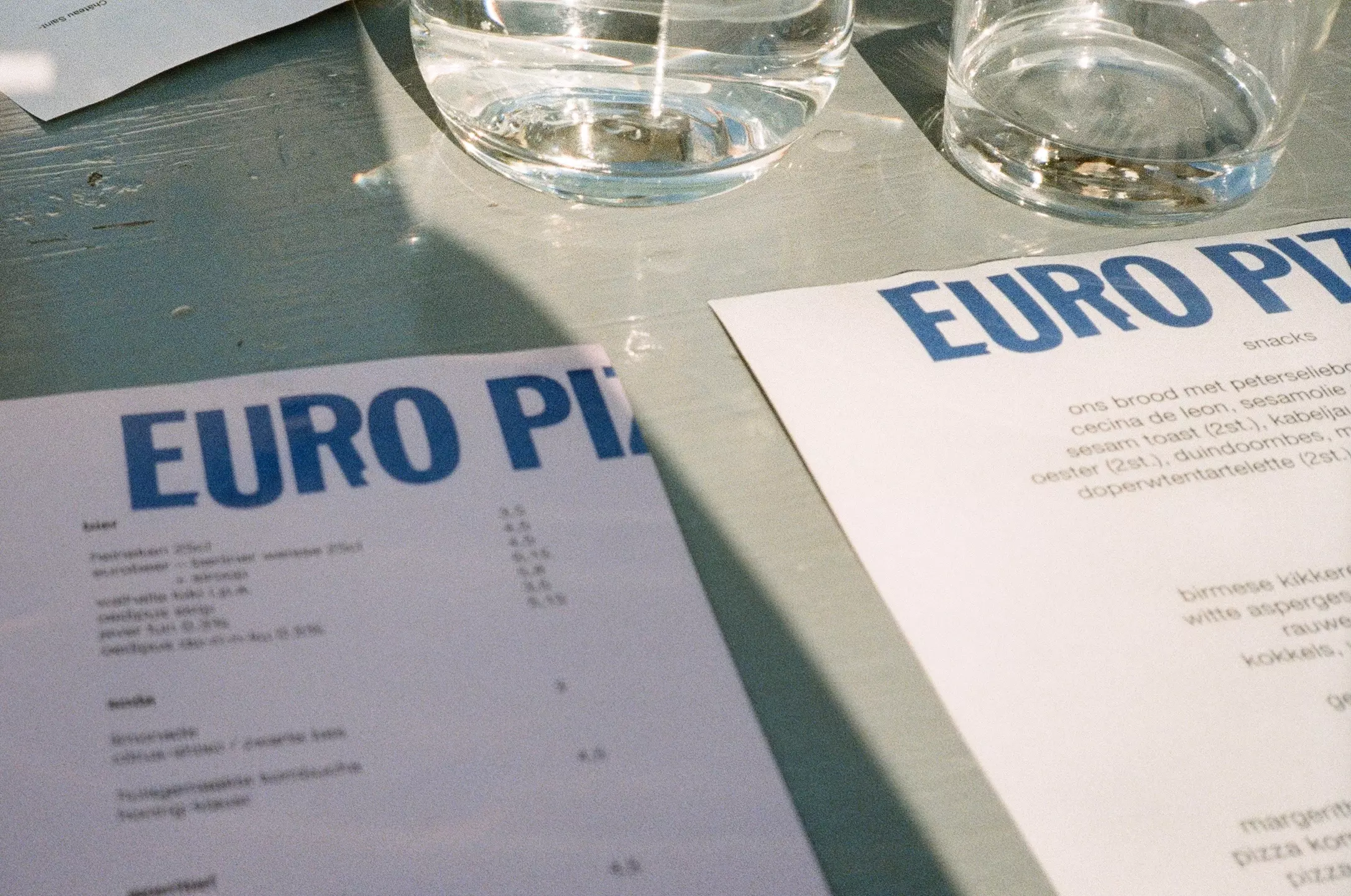 Close up shot of a food menu on a table with glasses of water