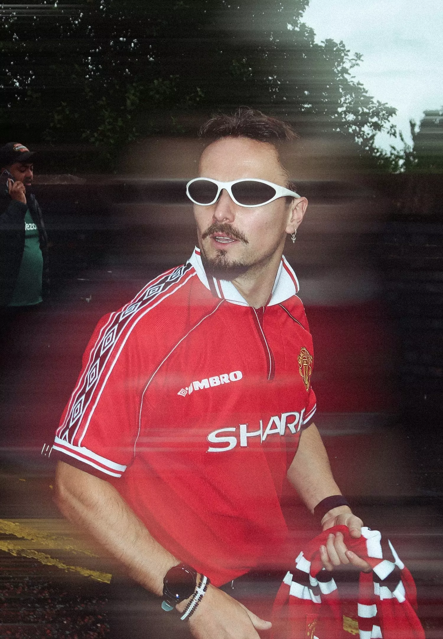 Motion blue of male wearing a vintage Manchester United shirt and white glasses